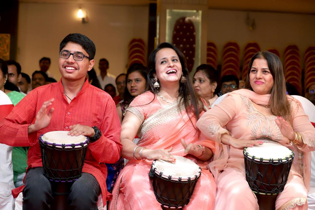 A group of people sitting and playing drums